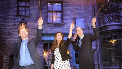 Prince Harry, Catherine, Duchess of Cambridge and Prince William raise their wands on the set used to depict Diagon Alley in the Harry Potter films in April 2013. Getty Images