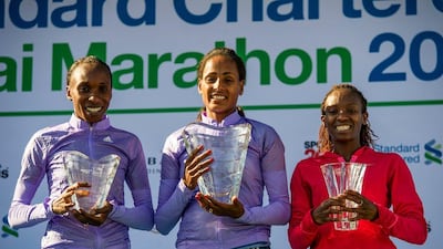 Aselefech Mergia, centre, displays her trophy after winning the Dubai Marathon on Friday. Stephen Hindley / AP / January 23, 2015