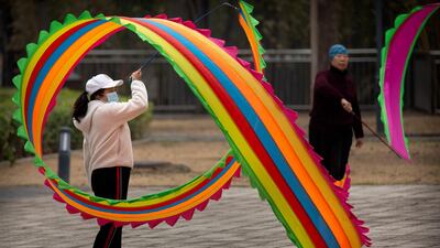 A woman twirls a flag at a public park in Beijing, China. AP Photo