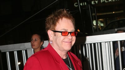 Elton John, in a red suit, arrives at the Move for Aids event in Sydney, Australia on November 30, 2006. Getty Images