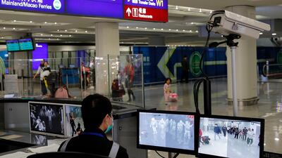 A health officer monitors passengers arriving at Hong Kong's international airport on January 4, 2020 as authorities step up screening for cases of a new viral pneumonia. AP Photo