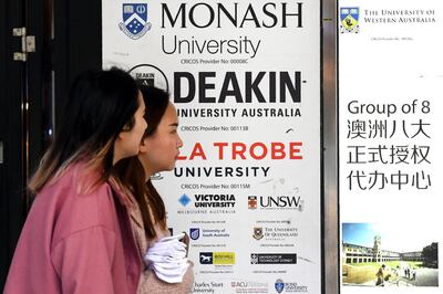 People walk past signage for Australian universities in Melbourne last week, as Canberra rejected Beijing's claims that students should be 'cautious' in choosing to study in Australia. AFP