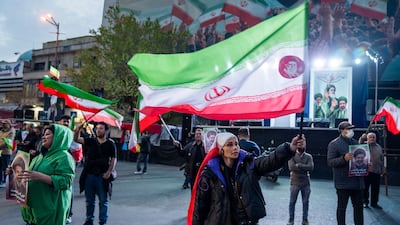 TEHRAN, IRAN - MARCH 22: People wave flags as they demonstrate in support of the Iranian government on March 22, 2026 in central Tehran, Iran. The United States and Israel continued their joint attack on Iran that began on February 28. Iran retaliated by firing waves of missiles and drones at Israel, and targeting U.S. allies in the region. (Photo by Majid Saeedi / Getty Images)
