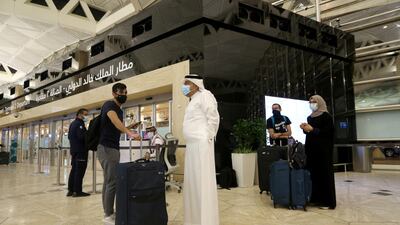 Travellers maintain social distancing as they wait to check-in their baggage at the King Khalid International Airport in Riyadh, Saudi Arabia. Reuters