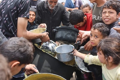 Palestinian children jostle for food at a charity kitchen set up at the Islamic University campus in Gaza City, on May 12. AFP