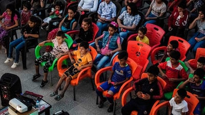 Children attend a film screening at a school yard in Shaghir Bazar.