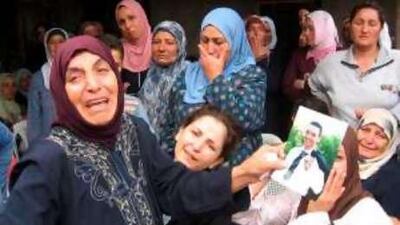 The mother of the slain Lebanese soldier Ali Mohammed Ali mourns his death outside her house in northern Lebanon.