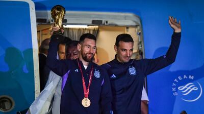 Argentina forward Lionel Messi, left, and national team boss Lionel Scaloni parade the World Cup during the team's arrival in Buenos Aires on December 20, 2022. Getty Images