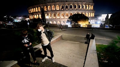 People wearing protective face masks near the Colosseum in Rome. AFP