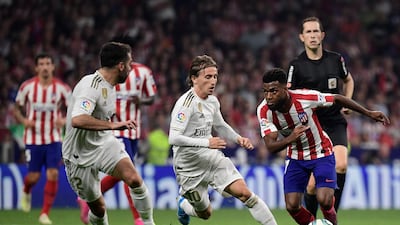 Atletico Madrid's French midfielder Thomas Lemar, right, vies with Real Madrid's Croatian midfielder Luka Modric. AFP