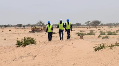 Two workers and their supervisor walk on their first day of work at the site of what is slated to be Senegal's largest solar plant in Santhiou Mekhe, Senegal. Nellie Peyton / Reuters