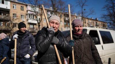 A woman cries before starting to clean the site where a bomb damaged residential buildings in Kyiv. AP Photo / Rodrigo Abd
