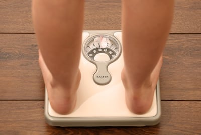 A woman uses a scale. PA