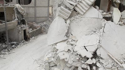 Residents walk out of a damaged building in Kafr Hamra village, in the northern Aleppo countryside. Aid groups hope to use the lull in fighting that has claimed 270,000 lives and displaced more than half the population to deliver desperately needed supplies. Abdalrhman Ismail / Reuters