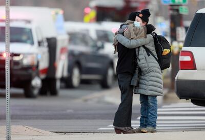 Women hug on the corner of Broadway and Table Mesa Drive where the mass killing took place. AP.