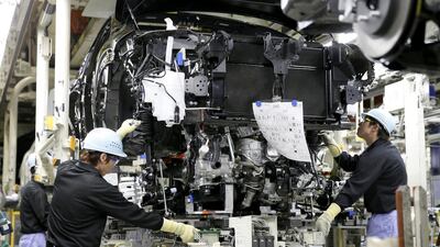 Workers mount a new turbo charged engine to a new sport utility vehicle Lexus NX 200t on a Toyota assembly line at Miyawaka. Kimimasa Mayama / EPA