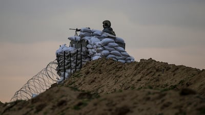 An armed member of a foreign security company watches from an observation point as Palestinians travel back to northern Gaza. EPA