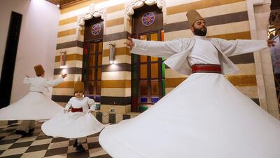 Yasser, Anas, and Muayad Al Kharrat dance at a restaurant in the Shahgur district. AFP
