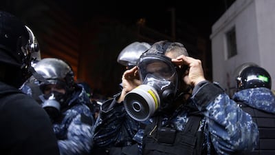 A Lebanese policeman adjusts his gas mask during clashes with supporters of Lebanon's former Prime Minister Saad Hariri, who burned tires and closed a road in Beirut, Lebanon. AP Photo