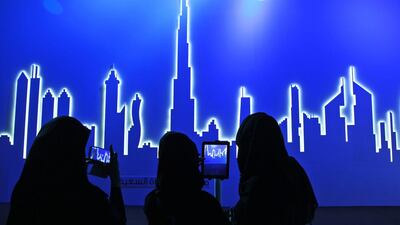 Emirati attendees take photos of an image of the city’s skyline in Dubai. After years of chasing the biggest and the best, Dubai is turning to technology to help the little things in life run more smoothly. Kamran Jebreili / AP Photo