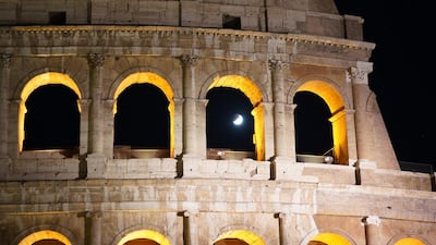 People watch a rising moon in Rome. AP Photo/Andrew Medichini