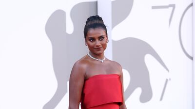 Simone Ashley wears a red Armani Prive column dress for the 'Bones and All' red carpet. Getty