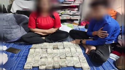 The wife and child of police station house officer Ramesh Chandra Sahani with bundles of notes worth 1.3 million rupees ($15,800)