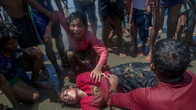 A Rohingya Muslim woman, who crossed ove rby boat from Myanmar into Bangladesh, wails beside her relativewho fell unconscious after the boat capsized at Shah Porir Dwip, Bangladesh, on Thursday, September 14, 2017. Nearly three weeks into a mass exodus of Rohingya fleeing violence in Myanmar, thousands are still flooding across the border in search of help and safety in teeming refugee settlements in Bangladesh. The woman survived. Dar Yasin / AP
