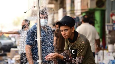 An Iraqi man cools off under a public shower at a street in central Baghdad, Iraq. EPA