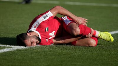 Palestine's Abdallah Jaber holds his leg as he lays on the floor. AP Photo