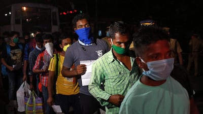 Migrant workers working in Kerala line up in Kochi to board a bus to their home state of Odisha. Reuters