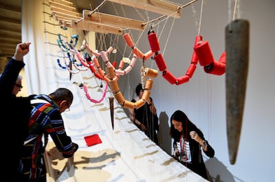 Visitor interact with the artwork 'A Stitch in Time' by Filipino artist David Medalla. AFP