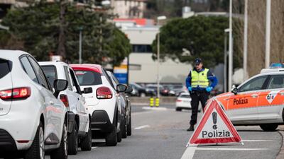 The Ticino cantonal police checks cars along the Italian-Swiss border after the Lombardy region was declared a red zone in Stabio, Switzerland. EPA