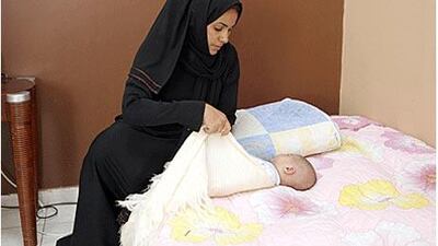 Atheeja Mohammed, a supervisor at the Social Care Centre for Children looks after a baby.