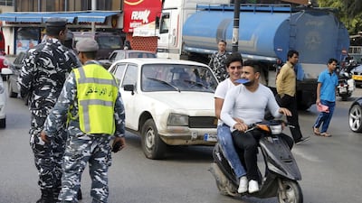 Men ride a scooter without helmets past policemen controlling traffic in Beirut on April 22, 2015, the day a strict new traffic law took effect in Lebanon. Mohamed Azakir / Reuters