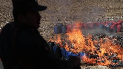 An Afghan security man stands guard during a drug burning ceremony on the outskirts of Kabul, Afghanistan, Tuesday. Rahmat Gul / AP Photo