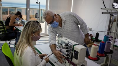 The Diamony Group Academy teacher, Pierre, shows a student the workings of a sewing machine.