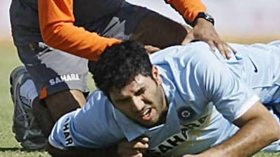 Yuvraj Singh winces in pain with back spasms in the first one day international while physio Nitin Patel attends to him in Rajkot on Friday. Yuvraj scored 138 runs in just 78 balls to take that first game away from England.