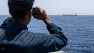 A sailor aboard the destroyer USS Rafael Peralta monitors a vessel while enforcing America's blockade against Iran. Centcom