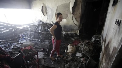 Katrina Cruiz examines the burnt-out remains of a fire on the seventh-floor of her apartment building in Abu Dhabi. She lives on the floor below and was forced to stay with friends for a few nights. Sammy Dallal / The National