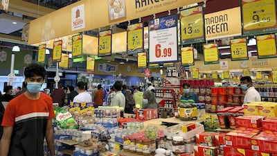 A shopper, wearing a protective mask, looks at shelves at a Nesto supermarket in Ajman during the Covid-19 outbreak. The National