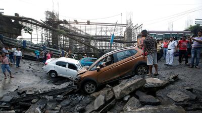 Onlookers stand next to the wreckage of vehicles at the site. Reuters