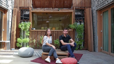 Noemie Jaupart and Axel Bule in front of the aquarium aquaponics wall.