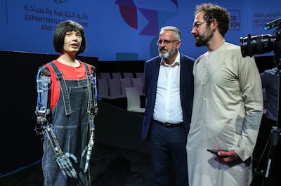Ai-Da speaks with Hareth Al Bustani of 'The National', right, as her creator Aidan Meller, centre, looks on. Victor Besa / The National