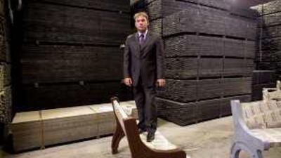 Gerry Sherard demonstrates the strength of a bench made of "eco-wood" while making his way through the warehouse of Eco Plastics Industries.
