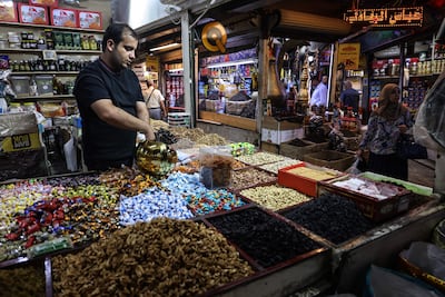 An Iraqi waits for customers at his shop in Baghdad. The IMF has sharply cut growth forecasts for the Middle East and Central Asia, as the ongoing war has sent economies into a tailspin. AFP