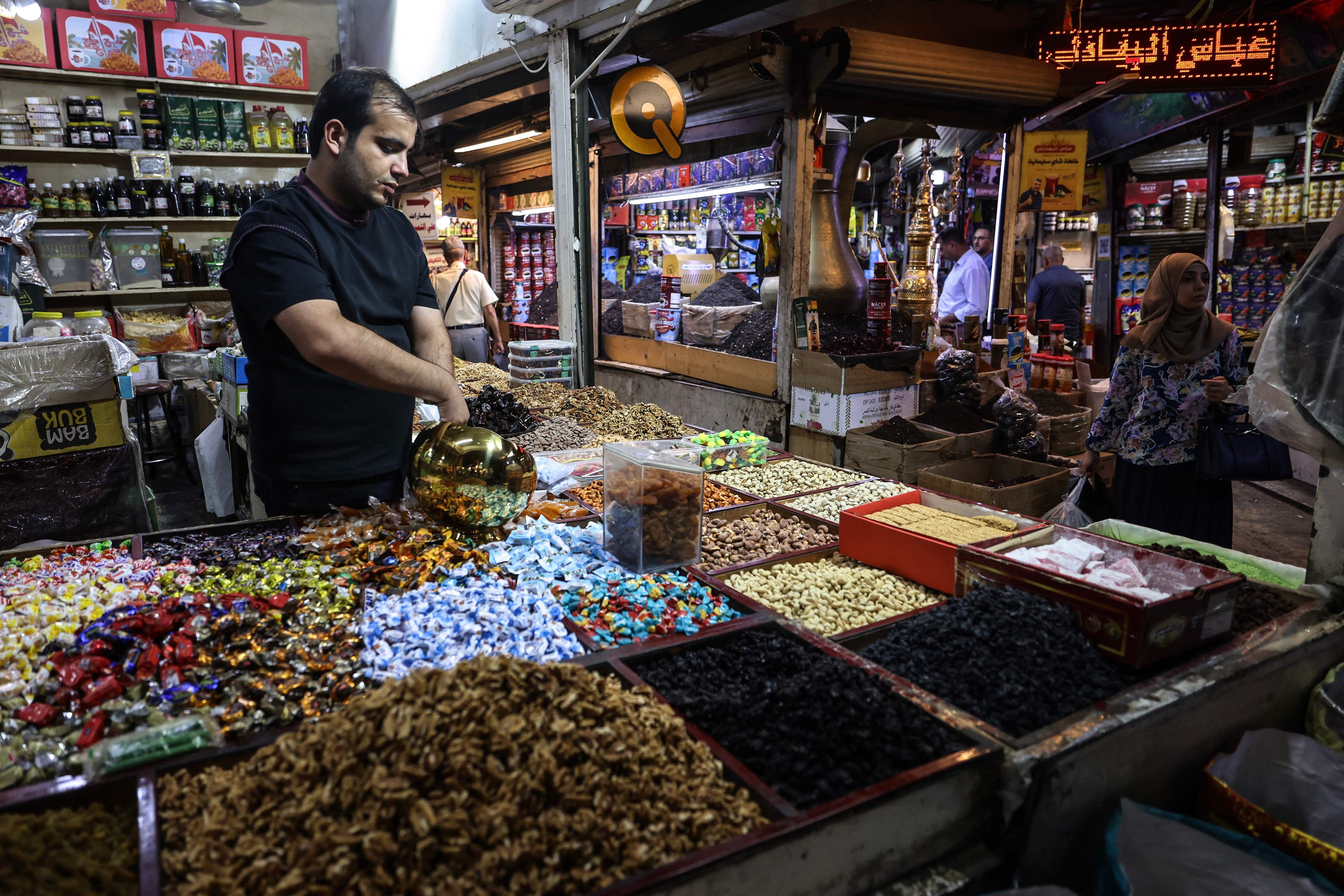 An Iraqi waits for customers at his shop in Baghdad. The IMF has sharply cut growth forecasts for the Middle East and Central Asia, as the ongoing war has sent economies into a tailspin. AFP