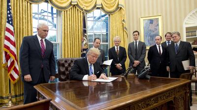 Donald Trump signs an executive order withdrawing the US from the Trans-Pacific Partnership. Ron Sachs / Pool via Bloomberg