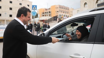 Ayman Odeh, Israeli Arab parliament member and leader of the Joint List alliance, hands a flier to a supporters during an election campaign event in then town of Yabeh, West Bank. AP