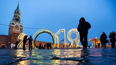 People walk past an installation for the new year on Red Square decorated for Christmas and New Year celebrations with the Spasskaya Tower in the background in Moscow, Russia. AP Photo
